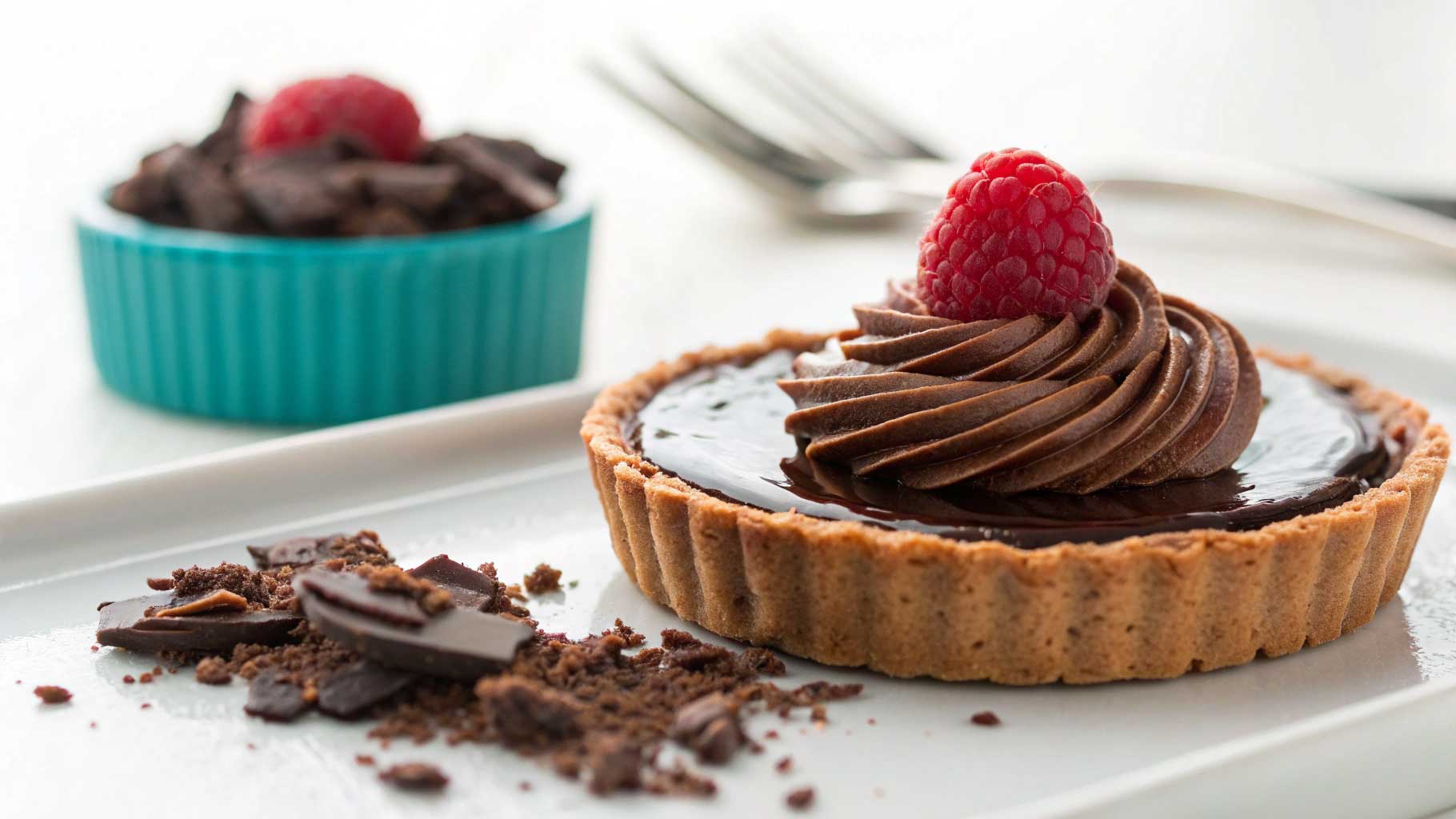Raspberry-topped chocolate tart highlighting sustainable chocolate and upcycled ingredients.